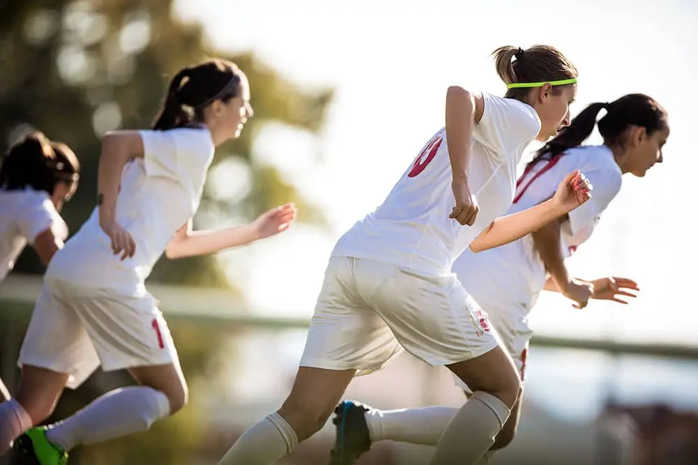 Women running on field during practice